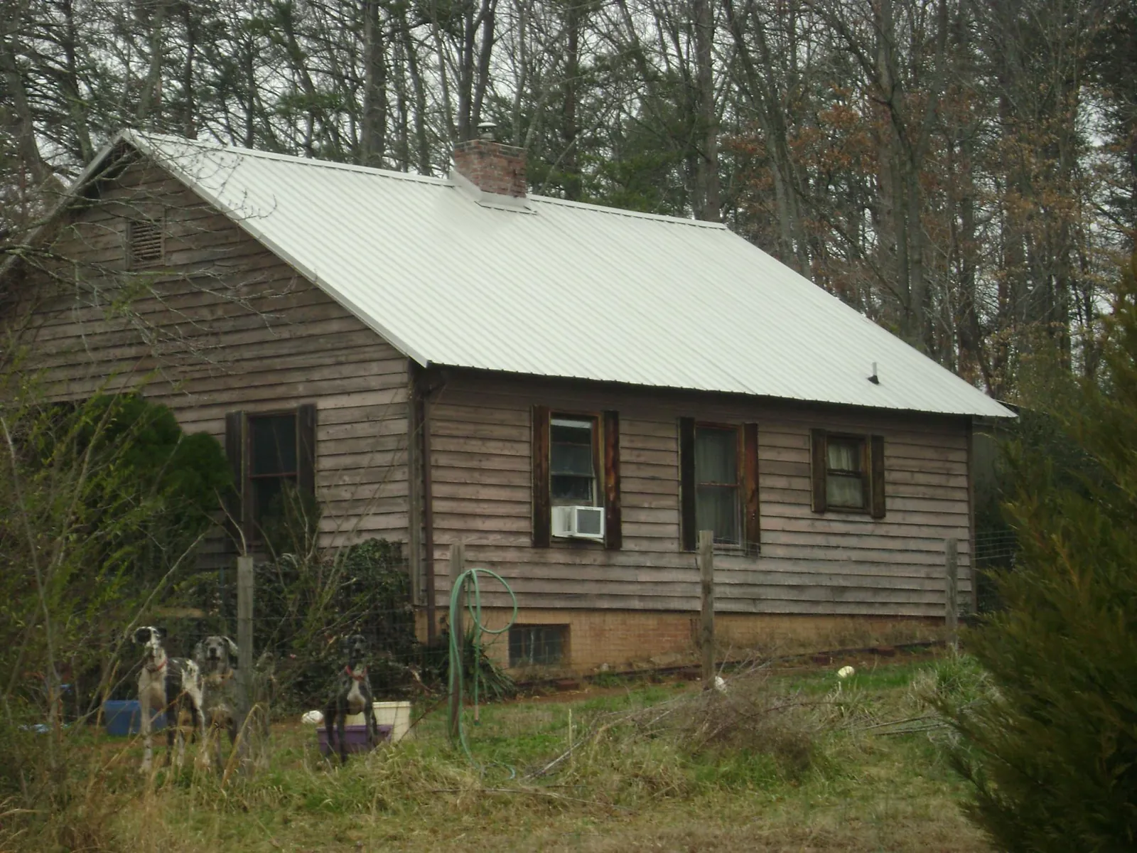 White metal roof on an old wood sided farmhouse, from a Metal Roof Installation job in Alexandria